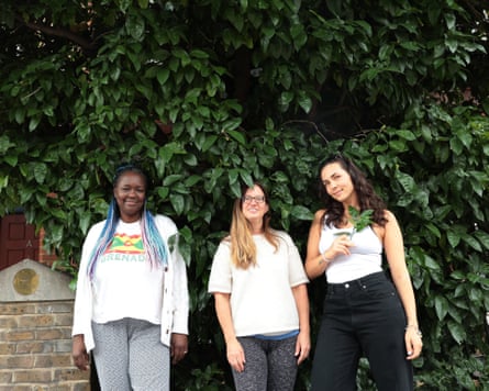 Three women in front of a vibrant green tree.