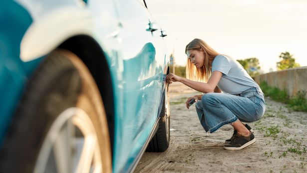 Woman checking tyre pressure
