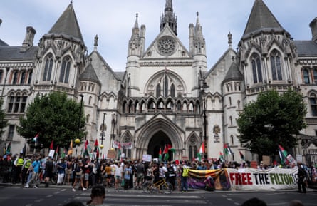 People hold flags outside the court building in central London