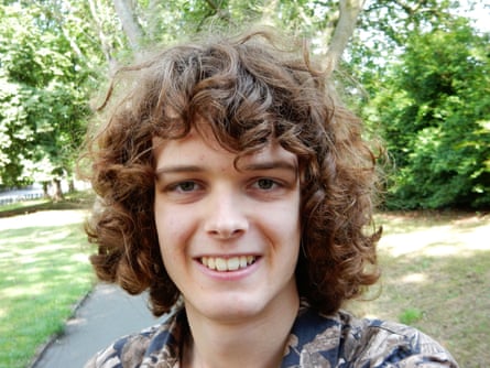 Jeremy Nunn: he is 19 with shoulder-length brown curly hair, and is smiling as he stands in a park.