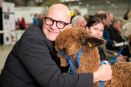 Man cuddles an alpaca