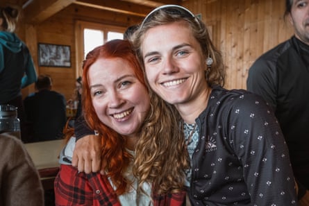 Two smiling young women in an Alpine hut.