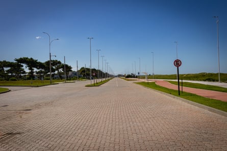 A view of a large empty space with paving and street lights but no people in sight