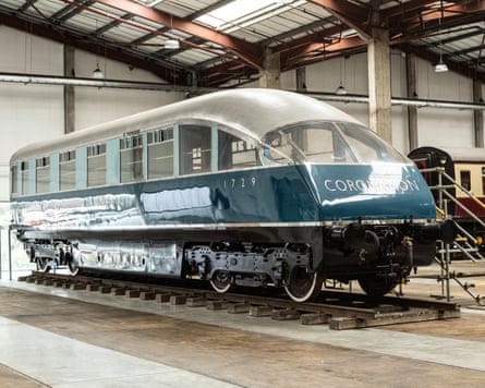 A blue train carriage in a warehouse