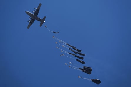 A plane overhead drops aid