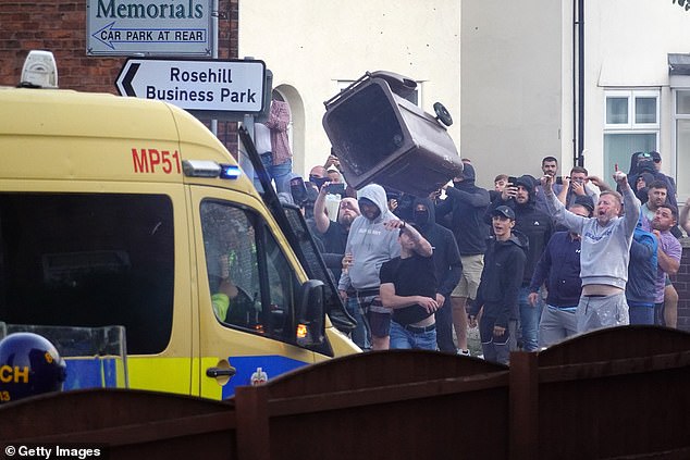 Riot police hold back protesters after disorder broke out on July 30, 2024 in Southport