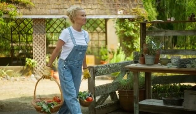 Anderson carrying wicker baskets of vegetables picked from her garden