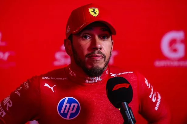 Lewis Hamilton speaks into a microphone