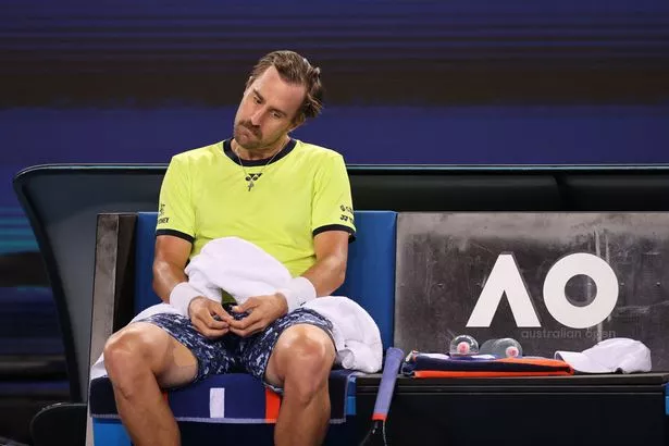 Steve Johnson of the US rests as he plays against Italy's Jannik Sinner during their men's singles match on day four of the Australian Open tennis tournament in Melbourne on January 20, 2022. 