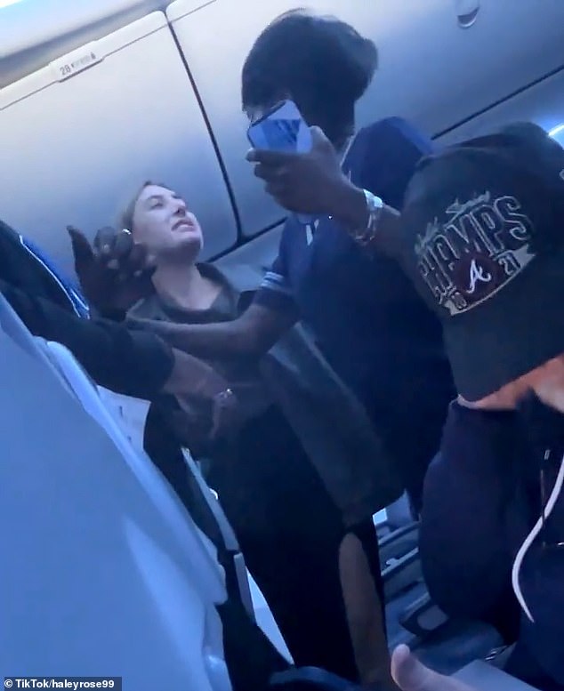 Once at the gate, the woman was escorted off as she made a snippy remark