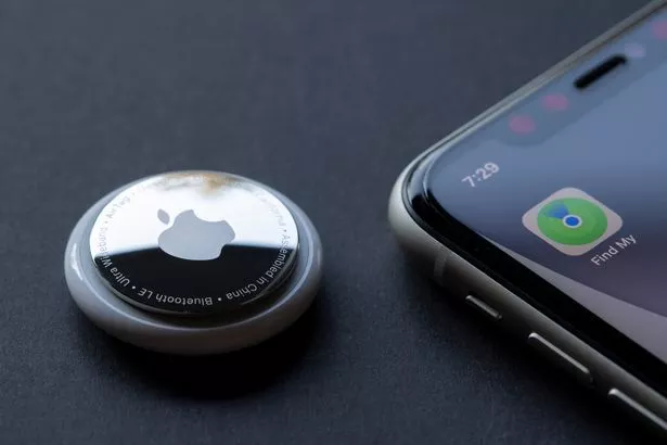 Find My app icon is seen on an iPhone next to an AirTag