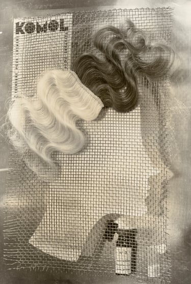 a black and white abstract photo made up of wiglets - both dark and pale, beauty products and a cut out of a woman’s face in profile