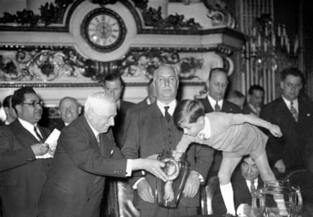 Jules Rimet holds the urn for his grandson Yves in Paris as he makes the draw for the 1938 finals