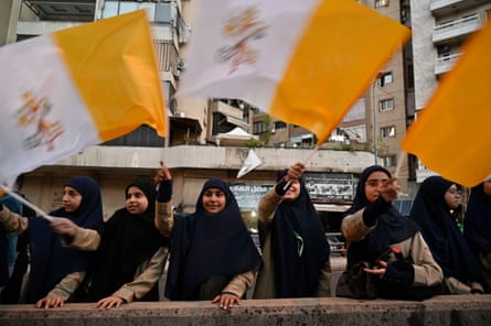 Women wave Lebanese and Vatican flags as the pope motorcade drives past in Beirut, Lebanon