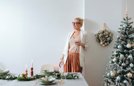 Woman drinking wine and setting up the Christmas table