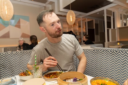 Peter chatting and eating at a restaurant table