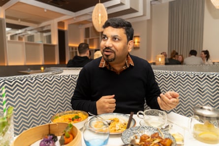Akshat chatting and eating at a restaurant table