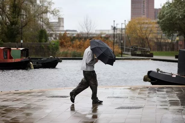 Man walking with umbrella in Manchester