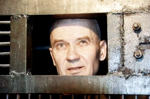 Andrei Chikatilo looks on from behind prison walls