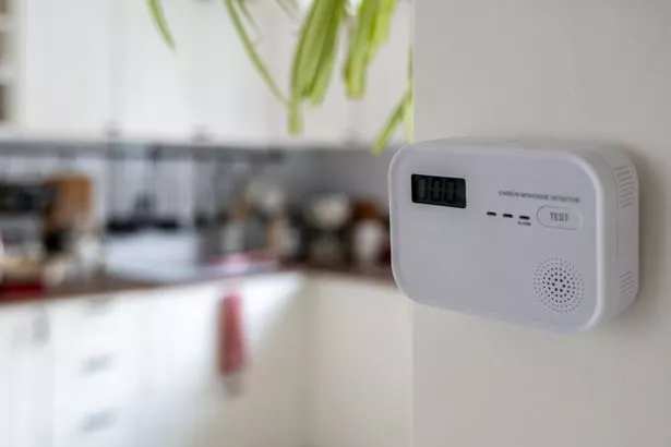 White carbon monoxide detector positioned on kitchen wall, ready to monitor air quality and ensure safety