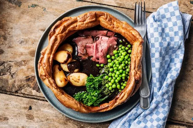 Feshly baked Yorkshire pudding that has been filled with a traditional “English roast dinner”