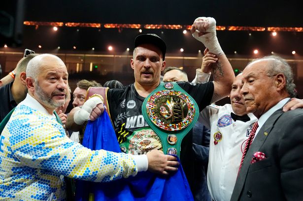 Oleksandr Usyk celebrates with his title
