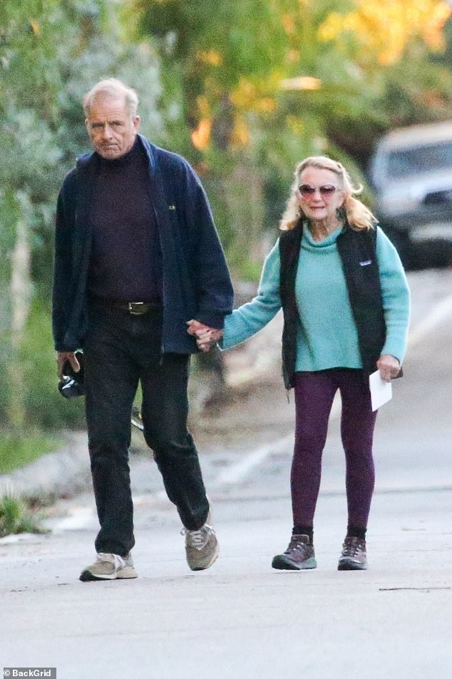 Maxwell lovingly held his wife's hand as they made their way down the road