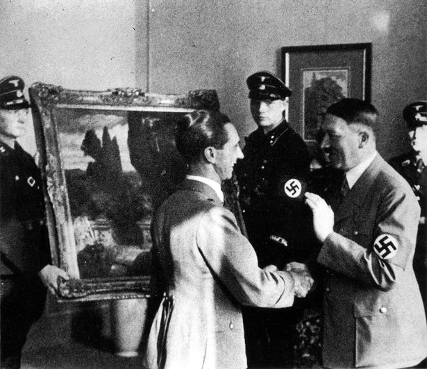 Hitler and Joseph Goebbels looking at works of art stolen from the Italians.