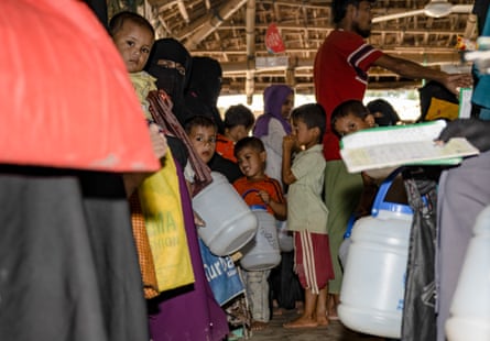 A large number of people holding plastic containers