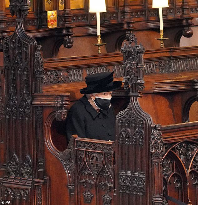 Queen Elizabeth sits alone in the pews of St George's Chapel at the funeral of Prince Philip in 2021