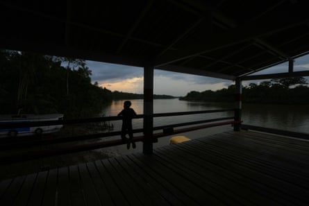 A boy waits for a boat at a deserted river harbour