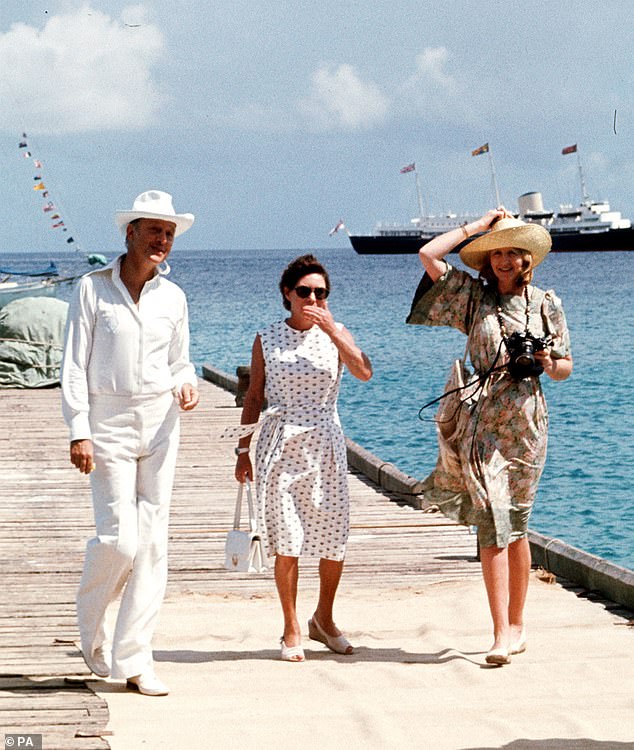 Princess Margaret, centre, with Lord Colin Tennant (left) and Lady Anne Tennant waiting on the jetty at Mustique to greet Queen Elizabeth II in 1977